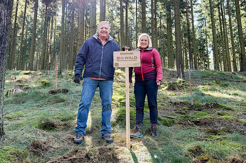 Dr. Peter Pfeilschifter und Julia Krügel hinter BHI-Wald-Schild