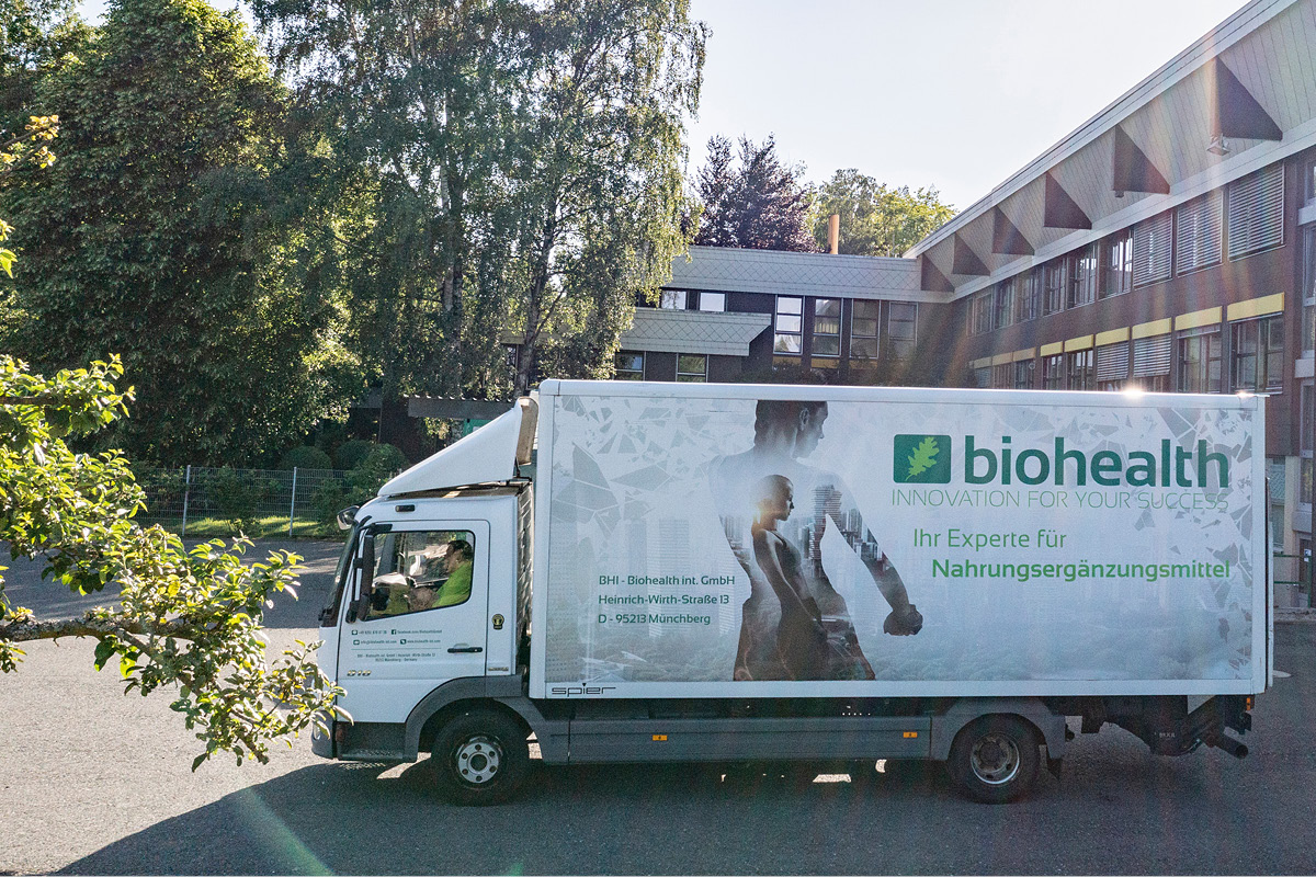 Biohealth LKW auf dem Firmengelände mit Baum im Vordergrund