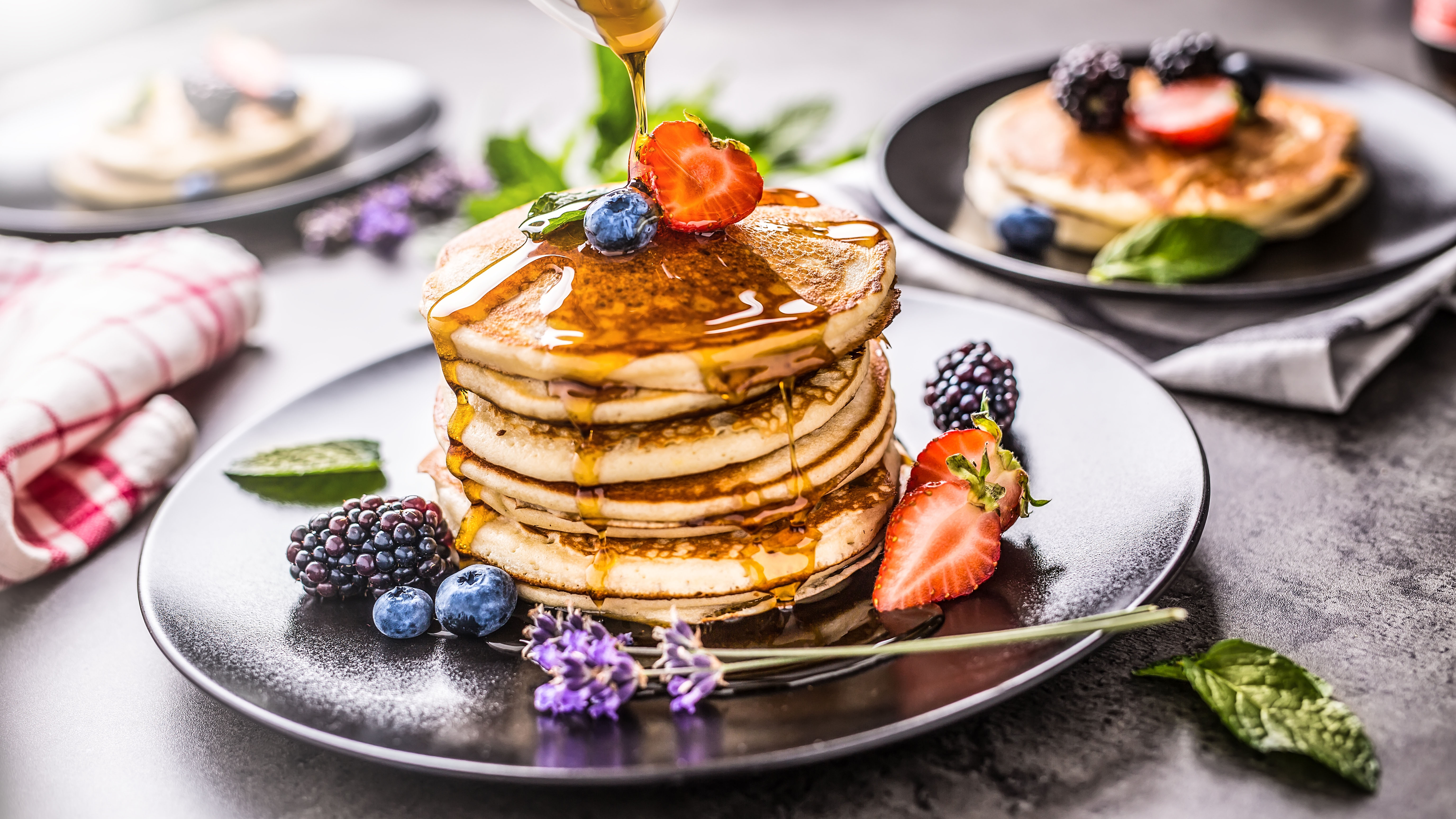 Pancakes aufgeschichtet zu einem Turm und dekoriert mit verschiedenen Früchten