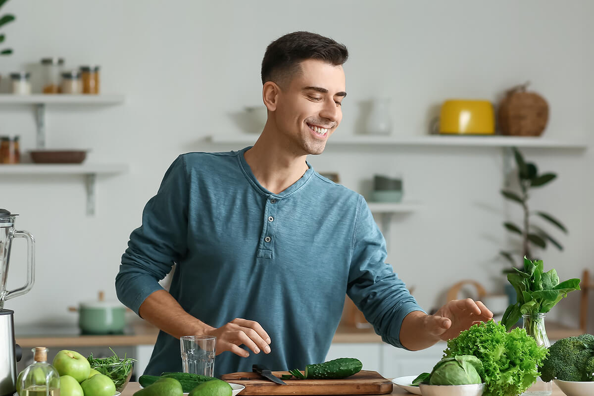 Mann in der Küche mit viel Gemüse