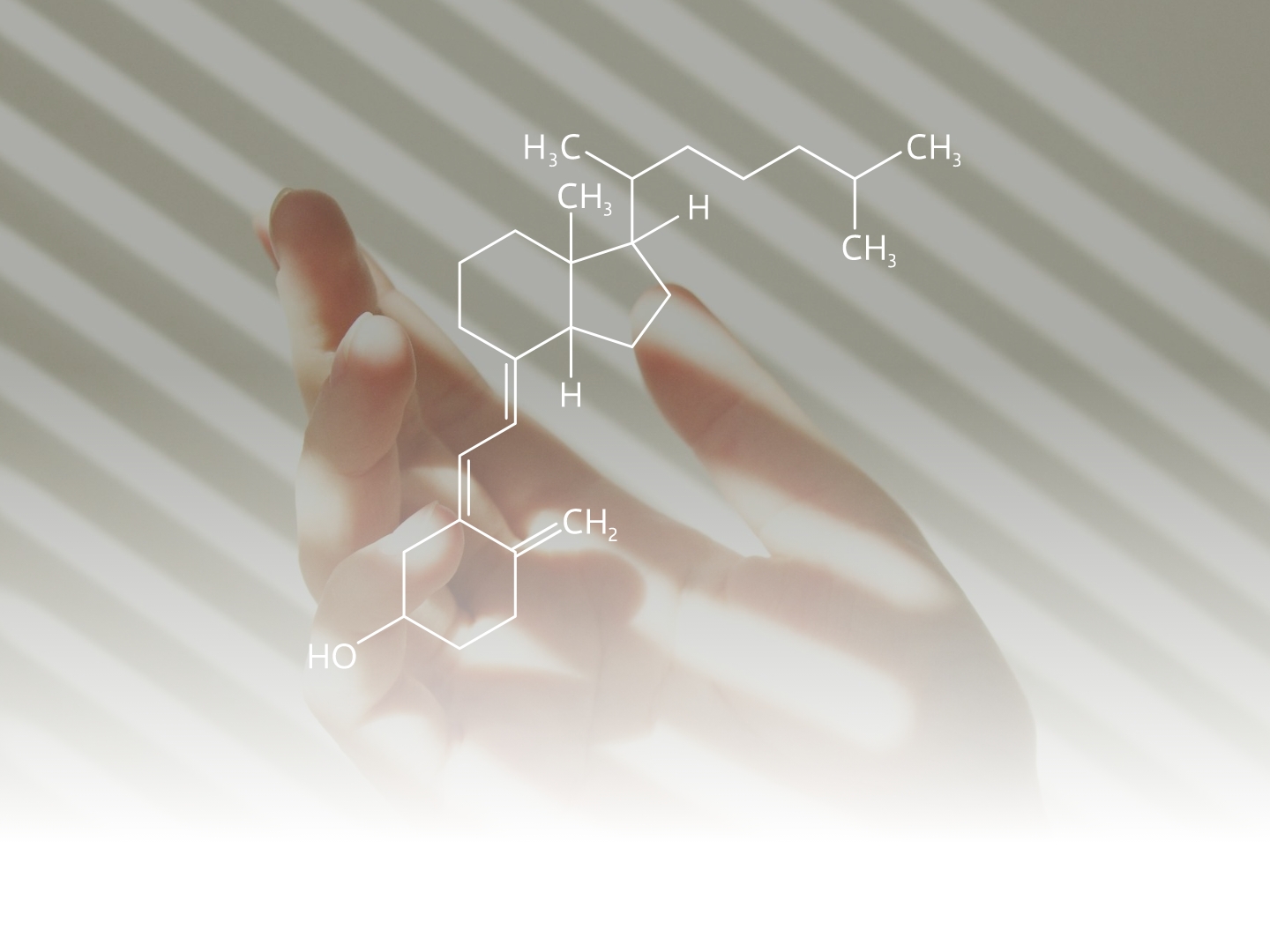 Abgesoftete Nahaufnahme von einer Hand mit leichten Streifen des Sonnenlichts, darauf die Strukturformel des Vitamin D