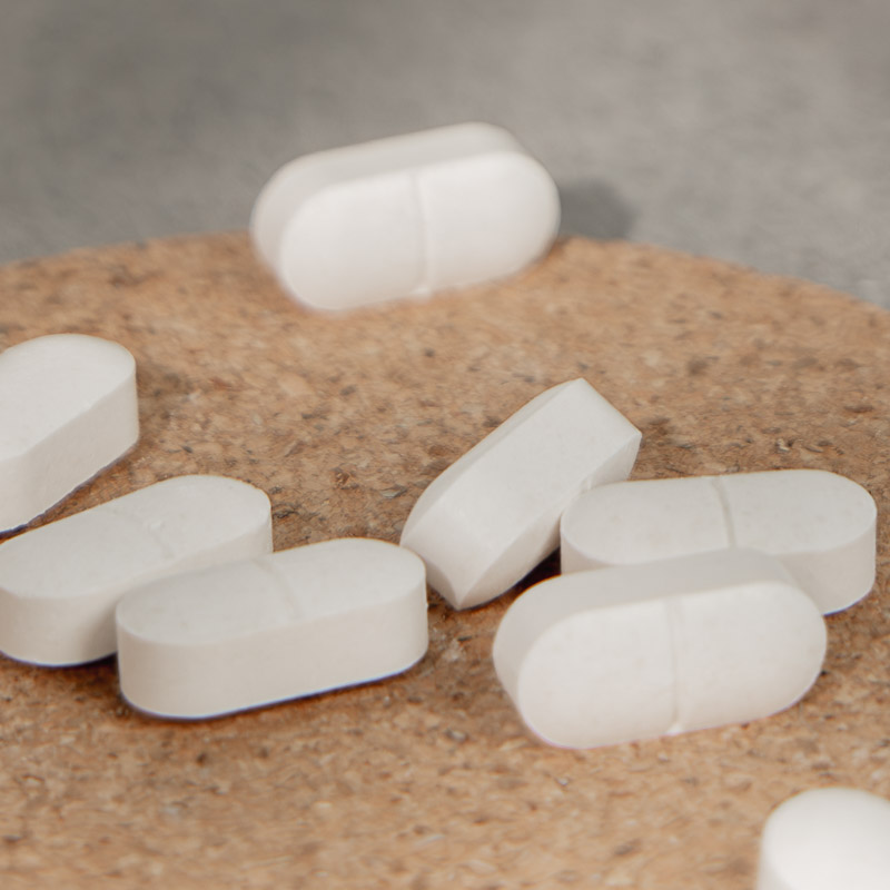 Nahaufnahme von Melatonin Tabletten auf einem Korkuntersetzer
