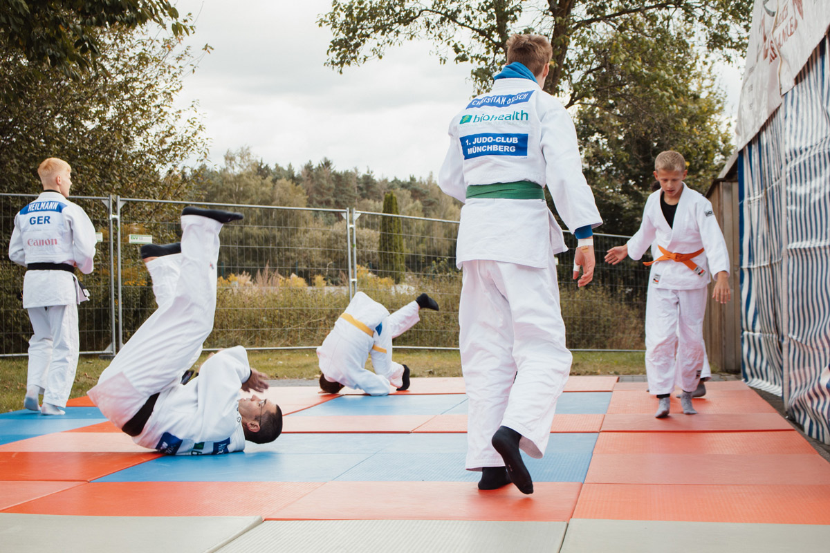 Judokämpfer des Münchberger Judoclubs führen auf einer rot-blauen Matte Judowürfe am BHI Familienfest vor